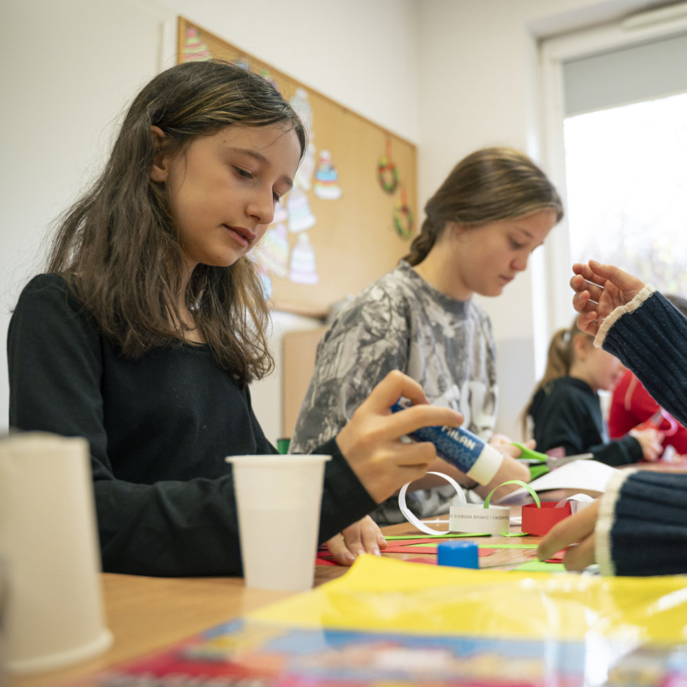Girls do crafts at a table during a Sunday school class